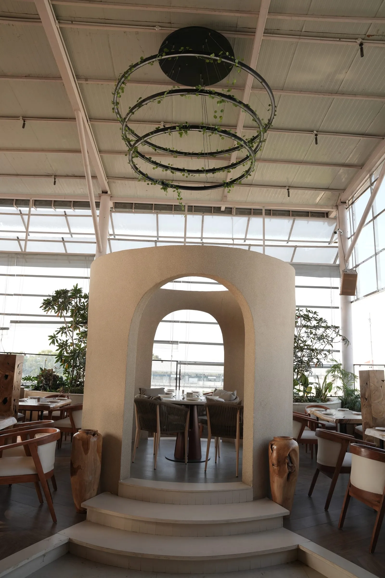 Layered cream arches beneath hanging green rings