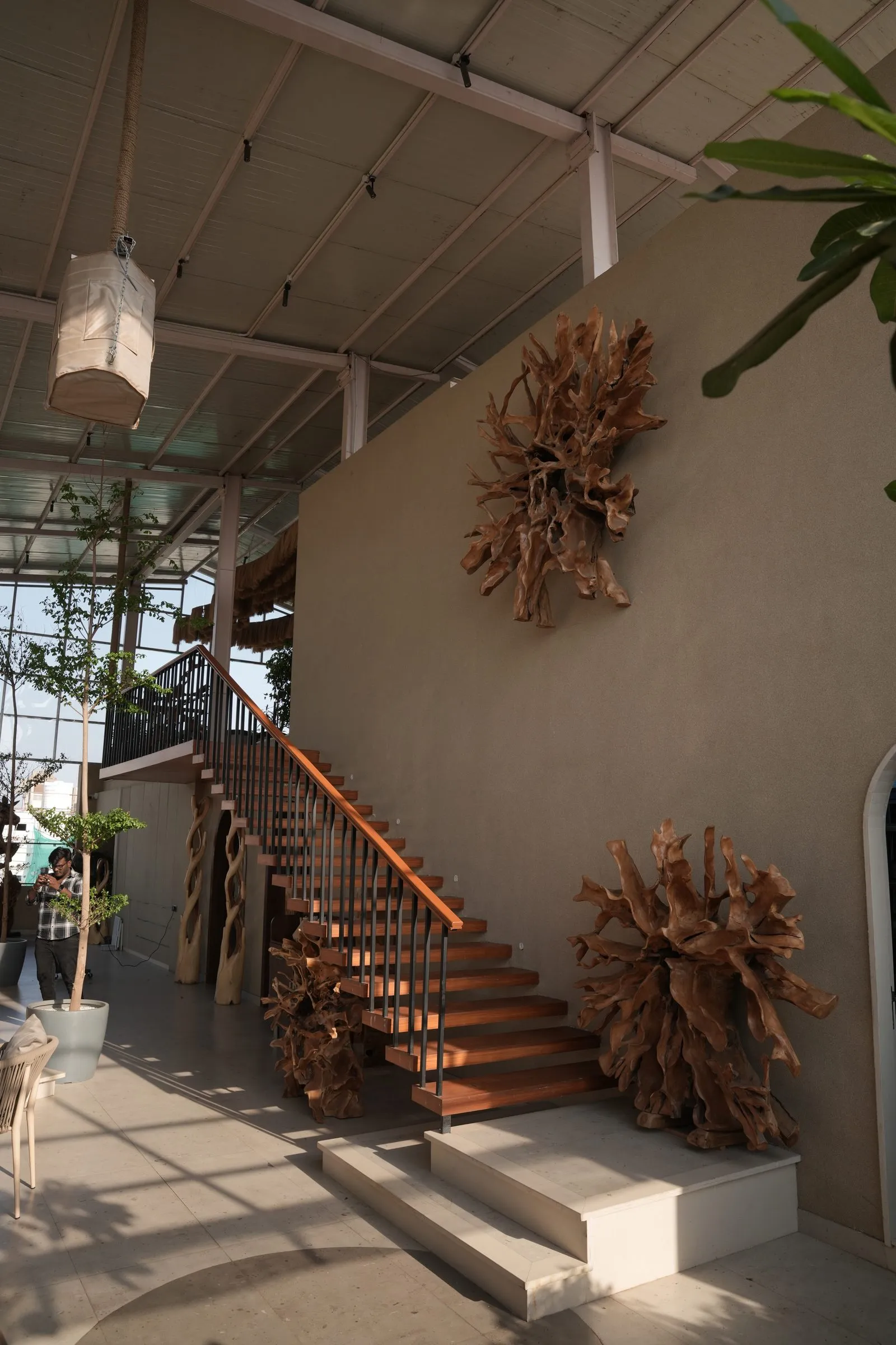 Terracotta staircase and a root sunburst sculpture in warm light