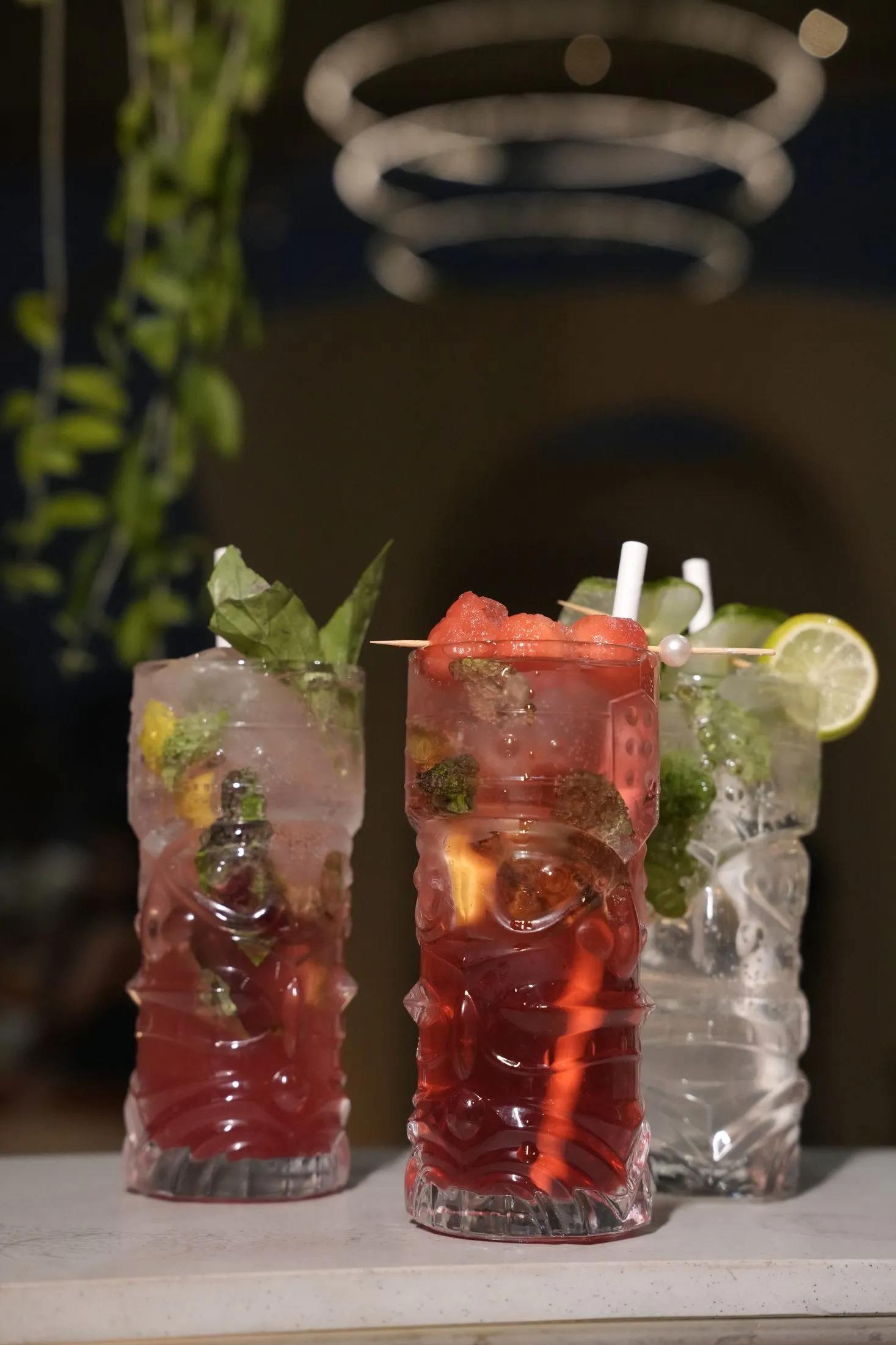 Three tiki-style glasses of mocktails with fresh mint